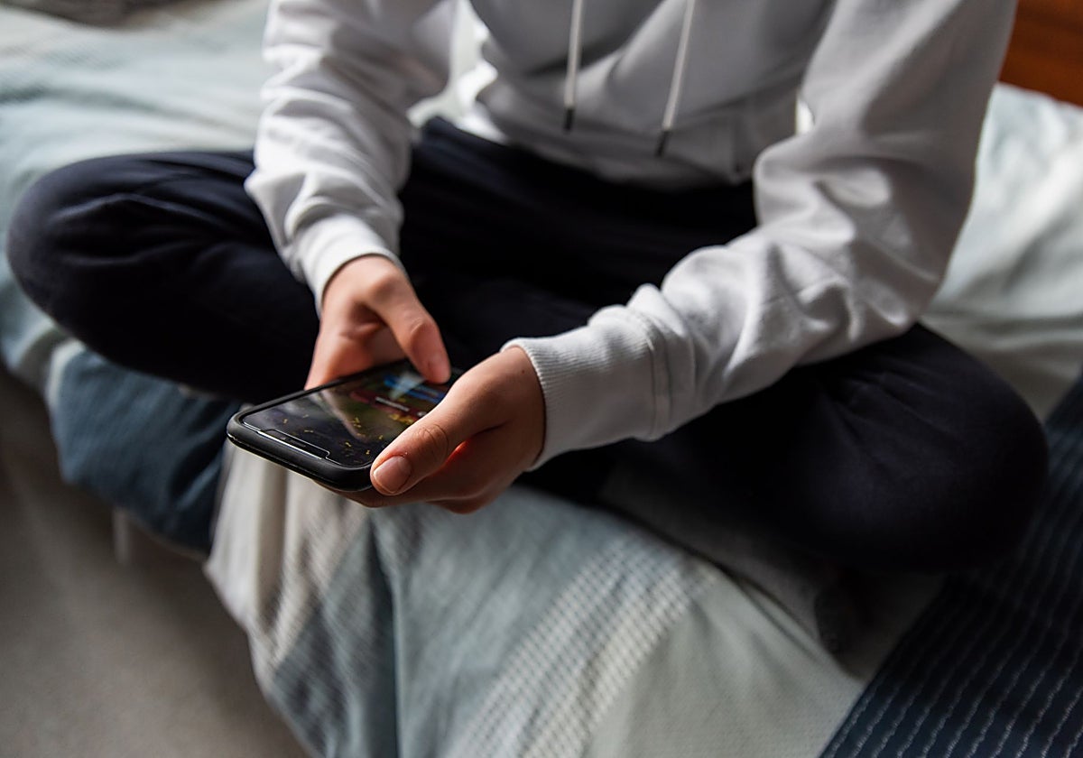 Un adolescente utiliza el teléfono móvil