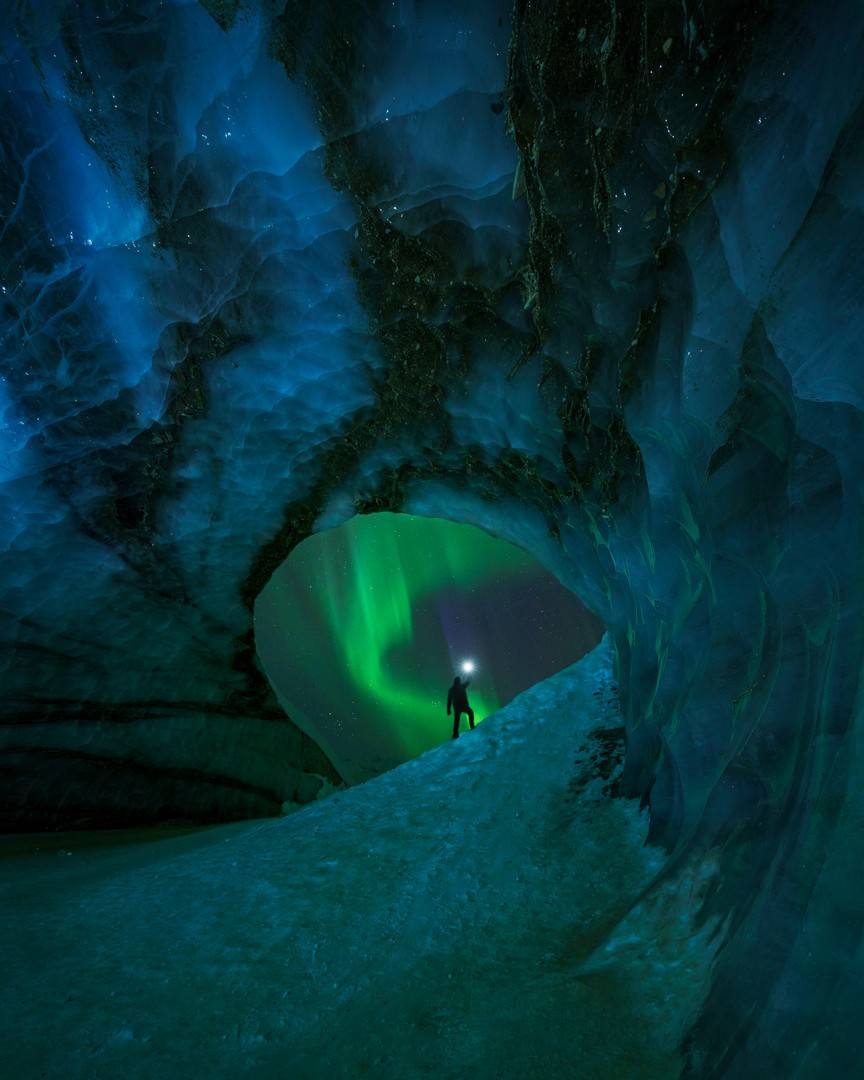 'Chasing the Light'. Foto tomada en Glaciar Castner, Alaska, EE. UU. "Lo que no aparece en esta foto son las varias noches que pasé en esta cueva a temperaturas bajo cero esperando a que una pizca de verde bailara a través de esta ventana helada. Después de fallar repetidamente, finalmente tuve otra oportunidad después de una noche de un increíble G2 con cielos despejados".