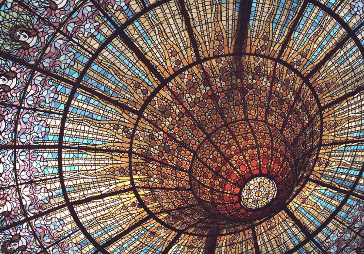 Vidriera en la sala del auditorio del Palau de la Música que representa una cúpula invertida de cristal polícromo con decoración de ángeles