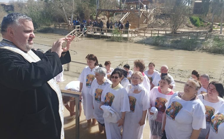 Imagen principal - En la foto superior, un grupo de ortodoxos rumanos en el lado israelí del río Jordán. Al fondo, el lado jordano. Cientos de personas acuden cada día para revivir la ceremonia del bautismo. Sobre estas líneas, a la izquierda, el padre Ricardo Bustos, franciscano, en el monte Tabor. A la derecha, un rincón de la antigua sinagoga de Cafarnaúm. 