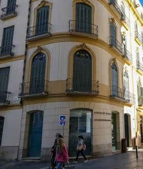 Imagen secundaria 2 - En la foto superior, la estatua de bronce de Picasso en la plaza de la Merced. Debajo, a la izquierda, la rebotica donde el padre de Picasso era tertuliano habitual. A la derecha, su casa natal, hoy centro de exposiciones