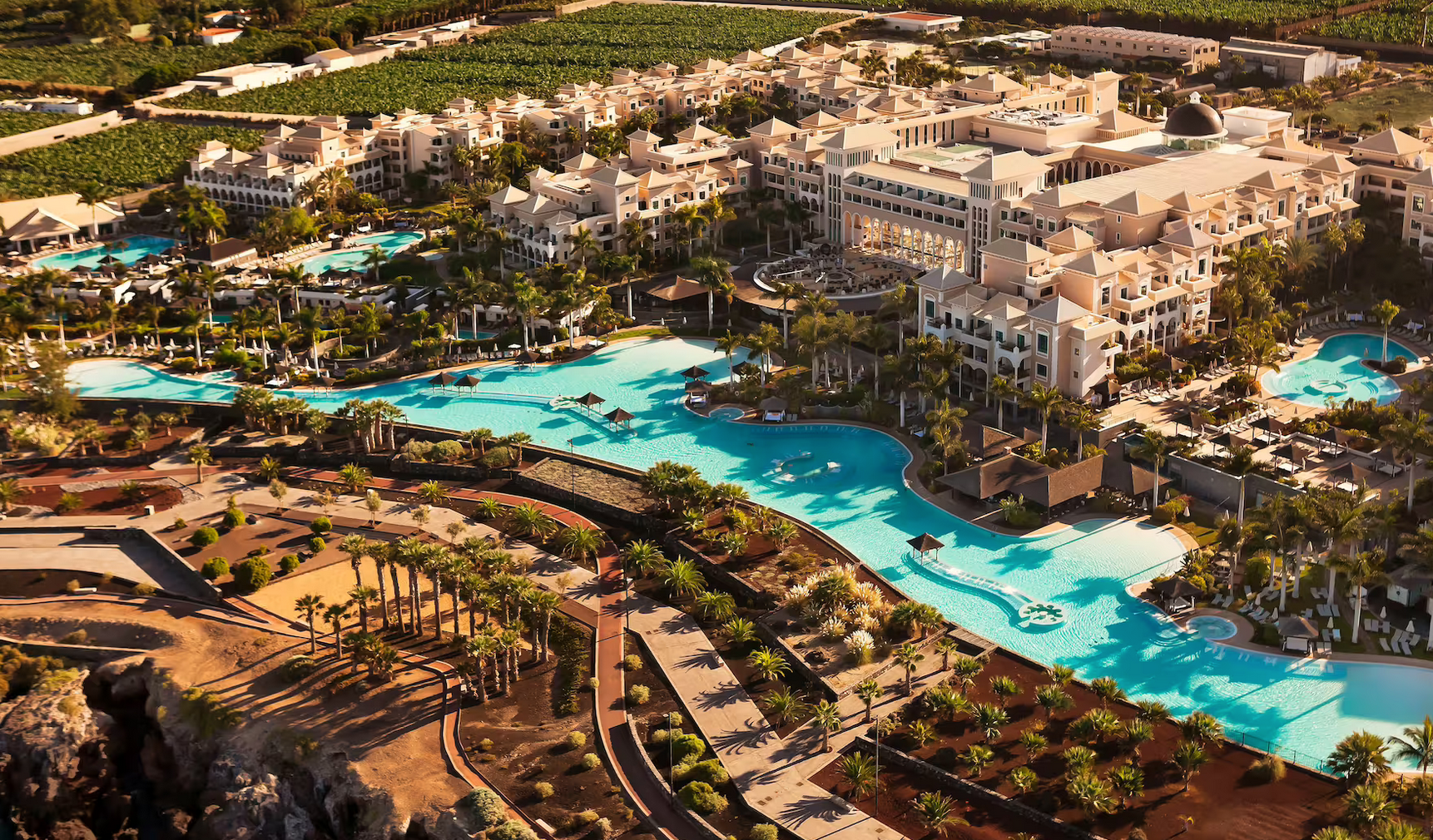 El Gran Meliá Palacio de Isora es un complejo de lujo perfectamente integrado en un excepcional entorno natural, frente al Atlántico y con el Teide a sus espaldas. Este alojamiento ofrece diferentes habitaciones y suites con todo tipo de comodidades, una variada oferta gastronómica que se compone de ocho restaurantes y bares y el Spa by Clarins, un templo de 2.000 metros cuadrados dedicado exclusivamente a la belleza, el bienestar y la salud en el que disfrutar de técnicas de masaje manual y diferentes tratamientos. Además, dispone de la experiencia RedLevel que brinda un paraíso hedonista a modo de hotel boutique dentro del propio resort –solo para adultos– en el que se da una atención exclusiva y personalizada a los huéspedes. Como colofón está su piscina infinita salada que presume de ser la más larga de Europa.