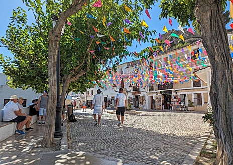 Imagen secundaria 1 - En frente del castillo de San José están los restos del Castillo de la Alcozaiba, también del siglo XI, con un complicado acceso (no se puede visitar) del que sólo queda una torre en ruinas. Sobre estas líneas, el túnel que da acceso a la zona con más historia de Guadalest, y la plaza en agosto, en días de fiesta