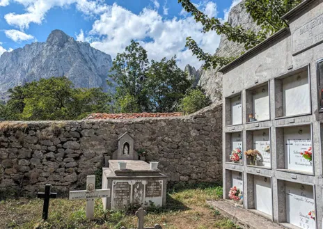 Imagen secundaria 1 - La cumbre del Naranjo de Bulnes está a 2.519 metros sobre el nivel del mar. A diez minutos a pie desde Bulnes está el mirador que podemos ver en la foto superior, en el que que se aprecia la reconocible silueta de esta montaña. En el pueblo comienzan infinidad de rutas por estas montañas. A la izquierda, el cementerio, en los Picos de Europa.