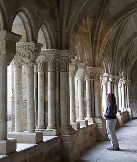 Imagen secundaria 2 - Arriba, la cavidad inicial de la Cueva del Cobre por la que aflora el río Pisuerga. Sobre estas líneas, a la izquierda, el Pico Espigüete (2450 m) reflejado sobre el embalse de Camporredondo. A la derecha, el claustro del monasterio de Santa María la Real, en Aguilar de Campoo