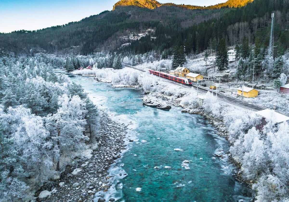 Tren de Oslo a Bergen, en un paisaje de montaña y agua en invierno, cerca de Bergen