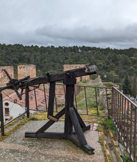 Imagen secundaria 2 - El Lozoya abraza la el pueblo medieval y su historia, en la que tuvo un papel importante Íñigo López de Mendoza, marqués de Santillana, señor de Buitrago en 1430, quien mandó construir su castillo-palacio. A la derecha, una de las máquinas de defensa que pueden verse en el adarve.