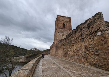 Imagen secundaria 1 - El Lozoya abraza la el pueblo medieval y su historia, en la que tuvo un papel importante Íñigo López de Mendoza, marqués de Santillana, señor de Buitrago en 1430, quien mandó construir su castillo-palacio. A la derecha, una de las máquinas de defensa que pueden verse en el adarve.