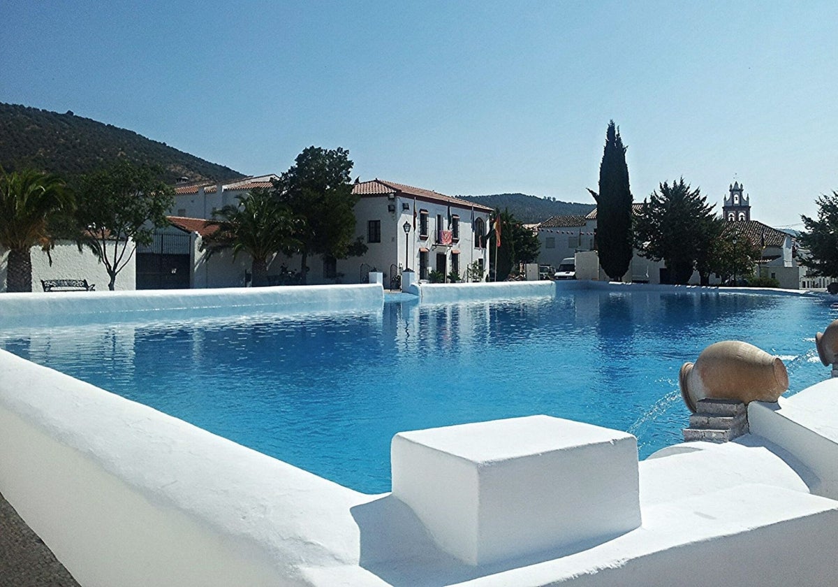 La alberca - piscina de Cañaveral de León, con el Ayuntamiento al fondo