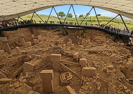 Imagen secundaria 1 - El yacimiento de Göbekli Tepe ha sido protegido por una carpa parecida a la de un campo de fútbol, con una pasarela desde la que miles de turistas observan cada día los bloques de piedra y los animales cincelados. Sanliurfa está lejos de los grandes centros turísticos de Turquía, pero es una zona clave en el desarrollo de la humanidad, cerca del Éufrates, lo que provoca un interés creciente.