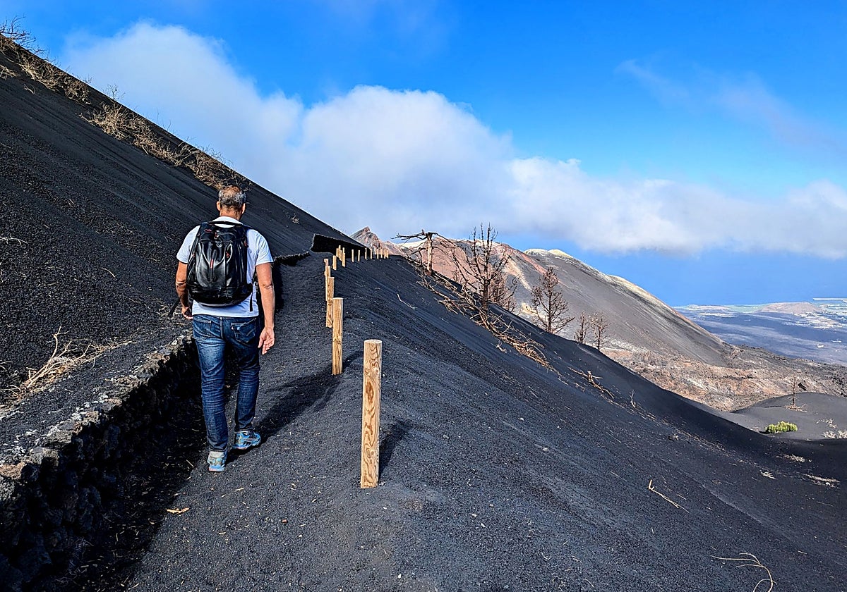 Ruta desde Llanos del Jable a un mirador situado a 300 m del volcán Tajogaite (al fondo de la imagen), con la ceniza de la erupción de 2021 y la colada rocosa del San Juan (1949) mezcladas
