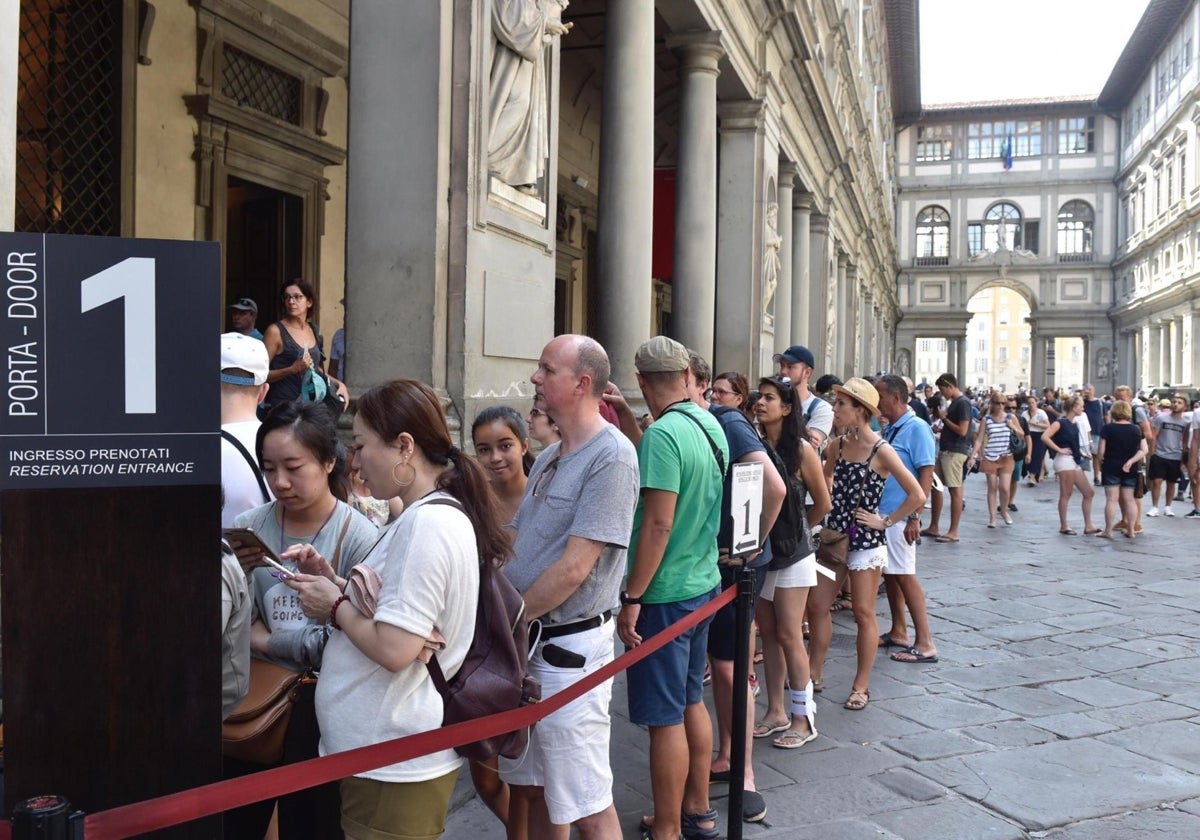 Turistas hacen cola para entrar en la Galería Ufizzi en Florencia