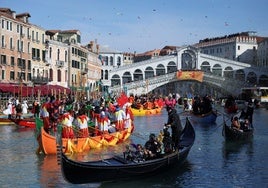 Miles de turistas se agolpan en el Puente Rialto de Venecia para ver el desfile del carnaval