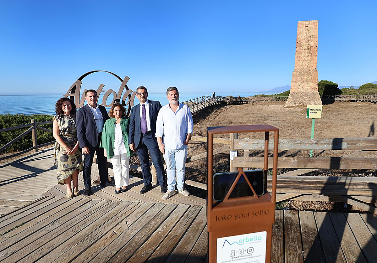 Representantes institucionales y de la empresa TURS posan junto a uno de los soportes para selfies instalados en las Dunas de Artola, en Marbella