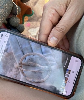 Imagen secundaria 2 - Trabajos de excavación en el santuario fundacional, restos cerámicos encontrados ya clasificados, e imagen de la fíbula