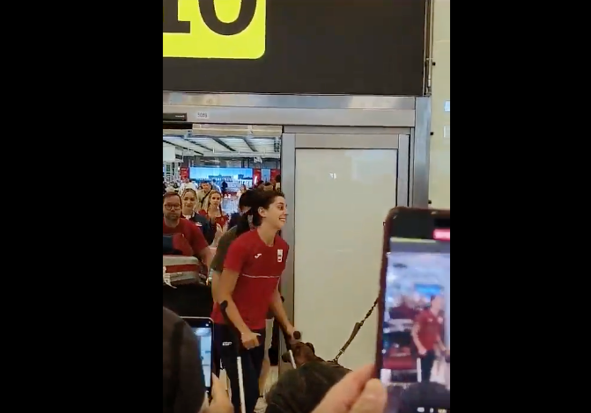 Carolina Marín, con muletas, sonríe ante el cariño recibido en el aeropuerto de Madrid