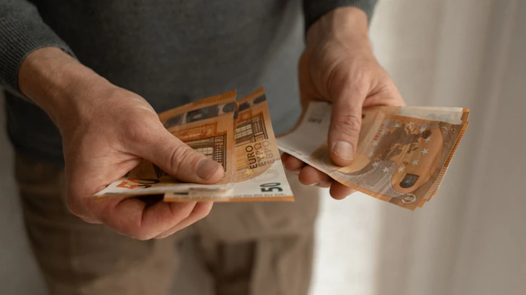 Imagen de una persona mayor contando billetes
