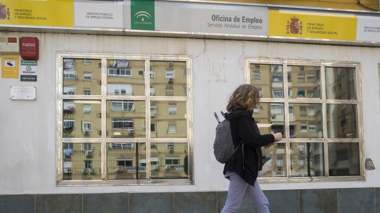 Una mujer pasando delante de una oficina de empleo
