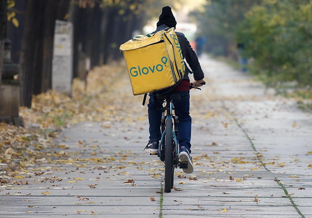 Imagen de archivo de un repartidor de Glovo en bici por una avenida