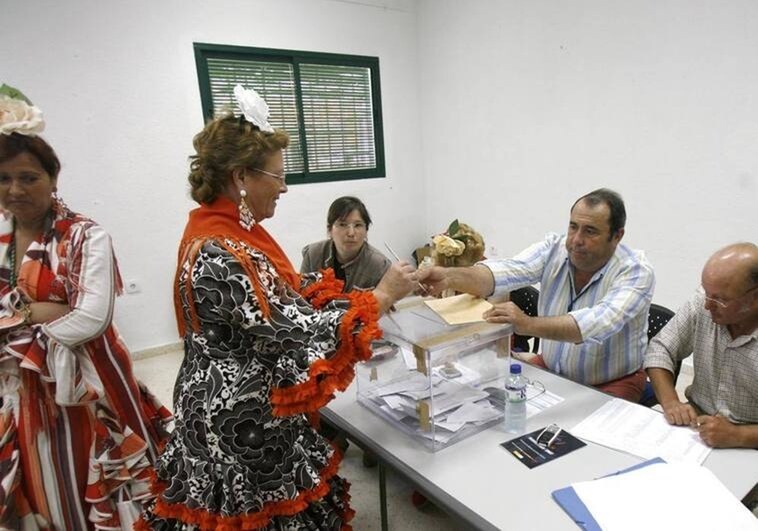 Una mujer, vestida de flamenca, vota en las elecciones municipales de 2015