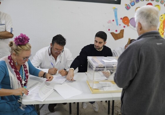 Una mujer con traje de gitana en la mesa electoral de El Rocío