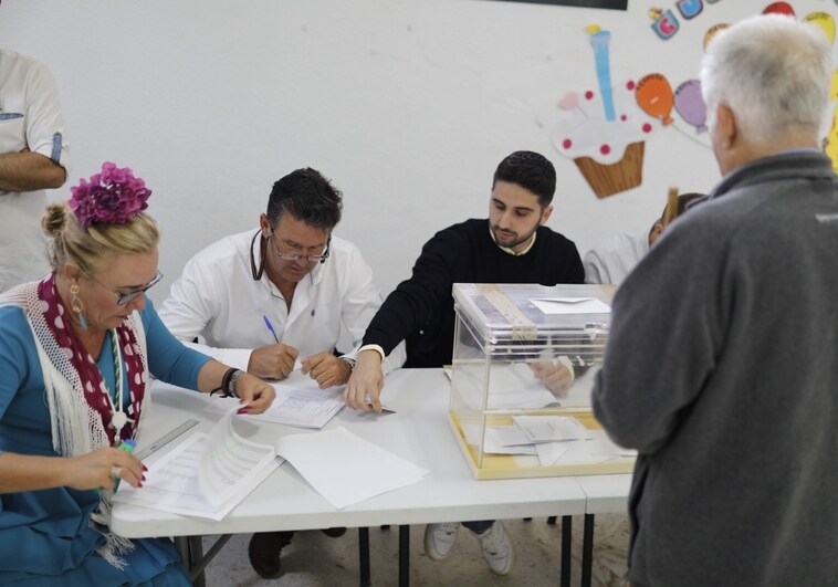 Una mujer con traje de gitana en la mesa electoral de El Rocío