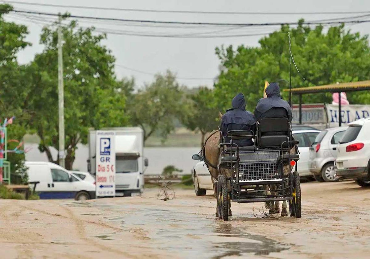 Un carro circula bajo la lluvia en la aldea de El Rocío