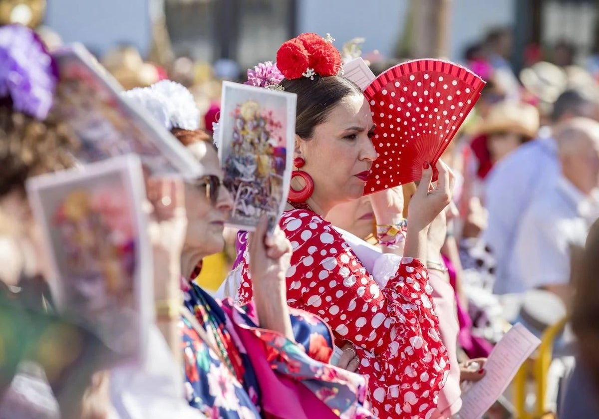 Fieles protegiéndose del sol en la misa pontifical del Domingo de Pentecostés de 2024 en El Rocío