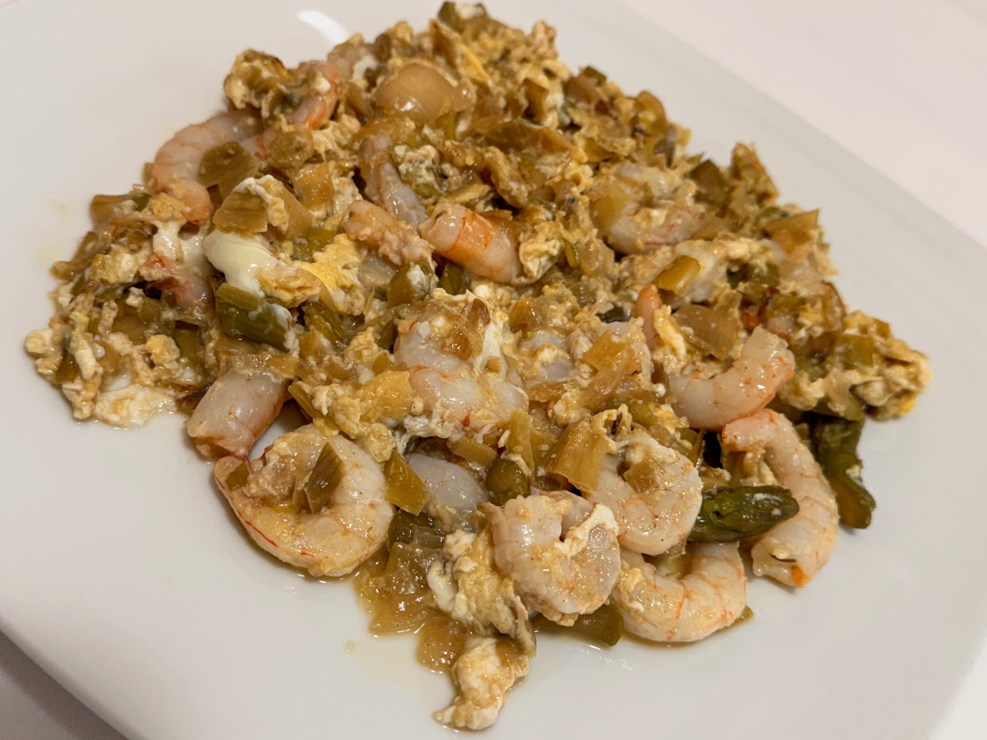 Revuelto de la casa con puerros confitados, espárragos verdes y gamba fresca, con un toque de manzanilla pasada