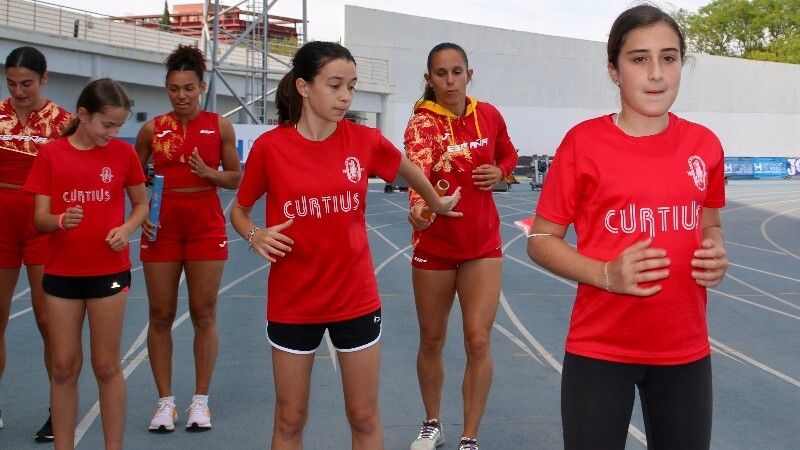 Jóvenes de las escuelas y clubes de atletismo de Huelva comparten entrenamiento con las atletas del relevo 4x100 femenino
