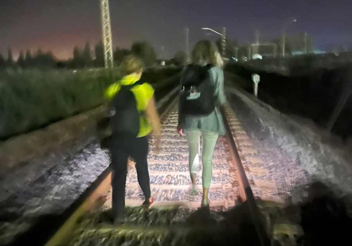 Dos chicas caminan por la vía de madrugada