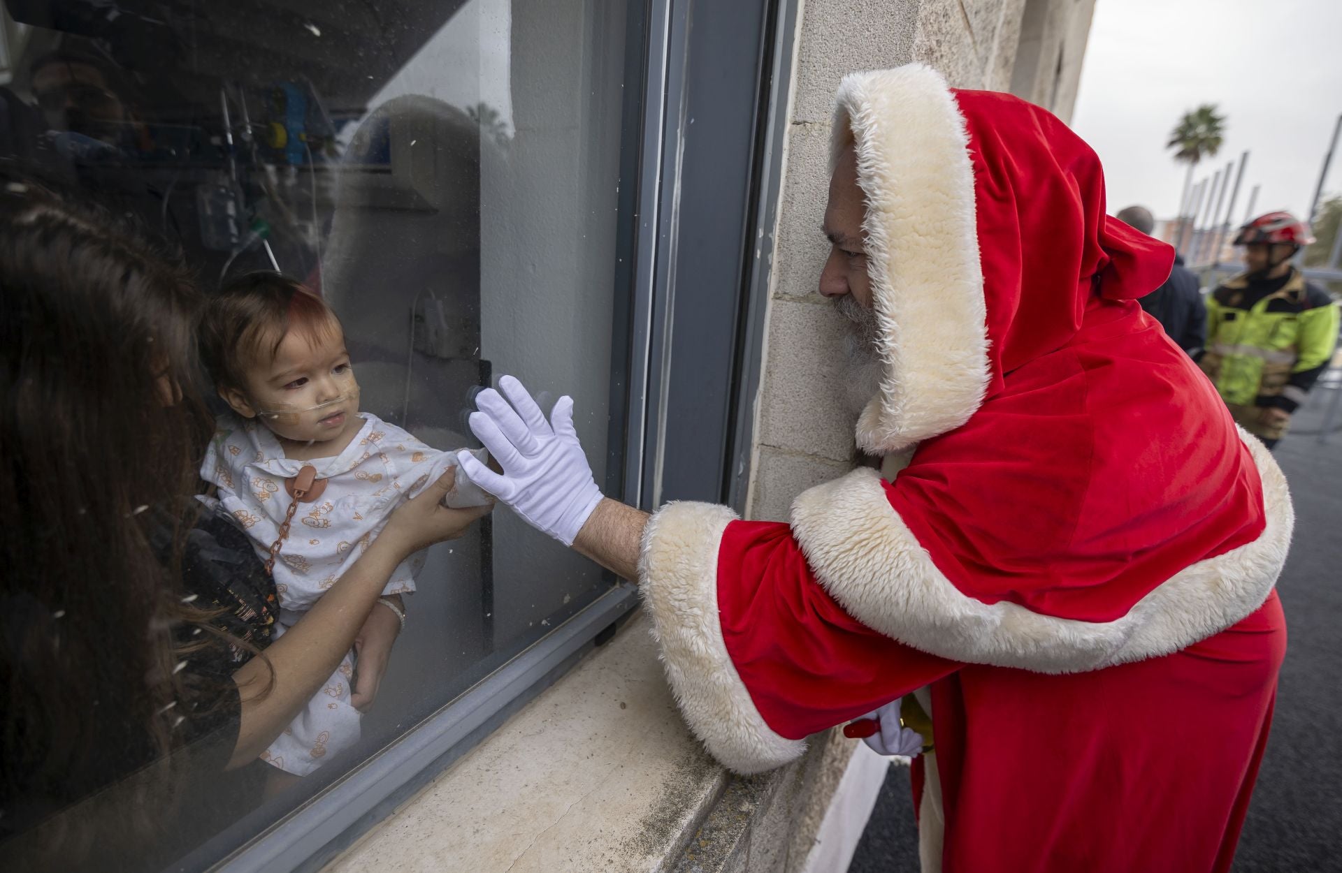 La visita de Papá Noel a los niños ingresados en el Hospital Juan Ramón Jiménez, en imágenes