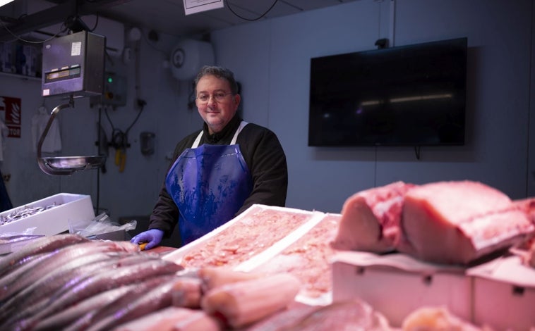 Imagen principal - Juan Carlos Salguero, el presidente de la Asociación de Detallistas del Mercado de San Sebastián, y abajo detalles del provisional en la Plaza Paco Toronjo