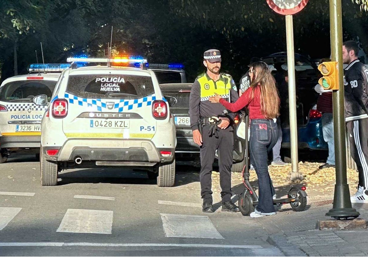 Un policía local para a una joven en patinete eléctrico