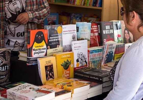 Una persona contempla la oferta de libros de un stand de la Feria de 2024