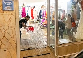 Una tienda del centro achica agua tras el aguacero sufrido