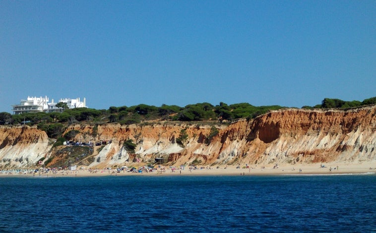 Imagen principal - La playa más bonita de Portugal para ver el atardecer está a una hora y media de Huelva: sus acantilados rojizos lo convierten en un lugar mágico