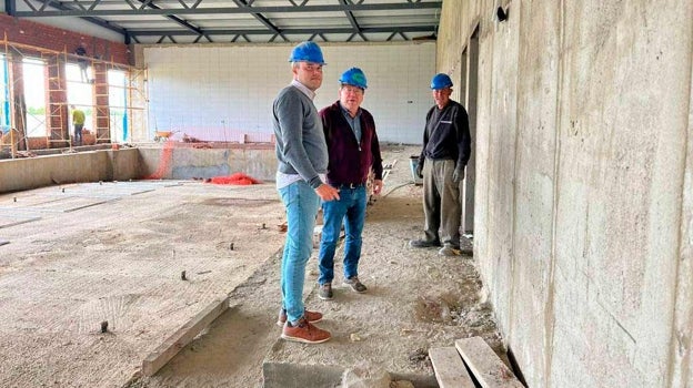 El anterior alcalde, en el centro, durante una visita a las obras de la piscina