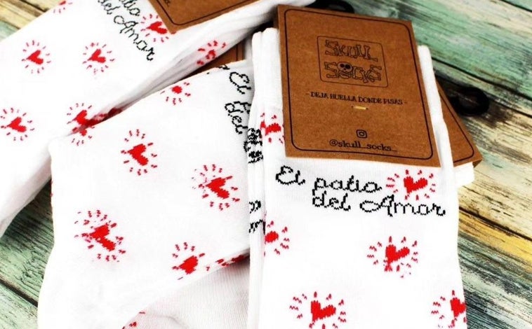 Imagen principal - Calcetines, camisetas y llaveros son algunos de lso artículos que se pueden comprar para colaborar con 'El patio del Amor'