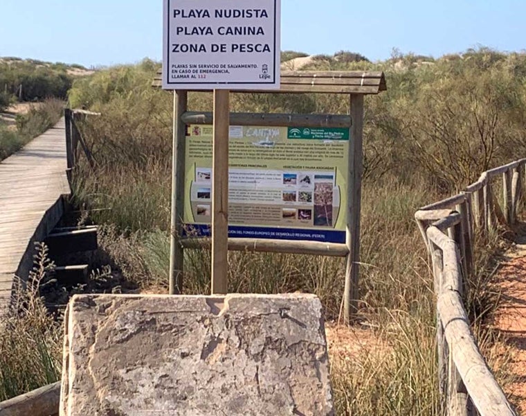 Cartel de acceso a la playa para perros y nudistas en el término municipal de Lepe