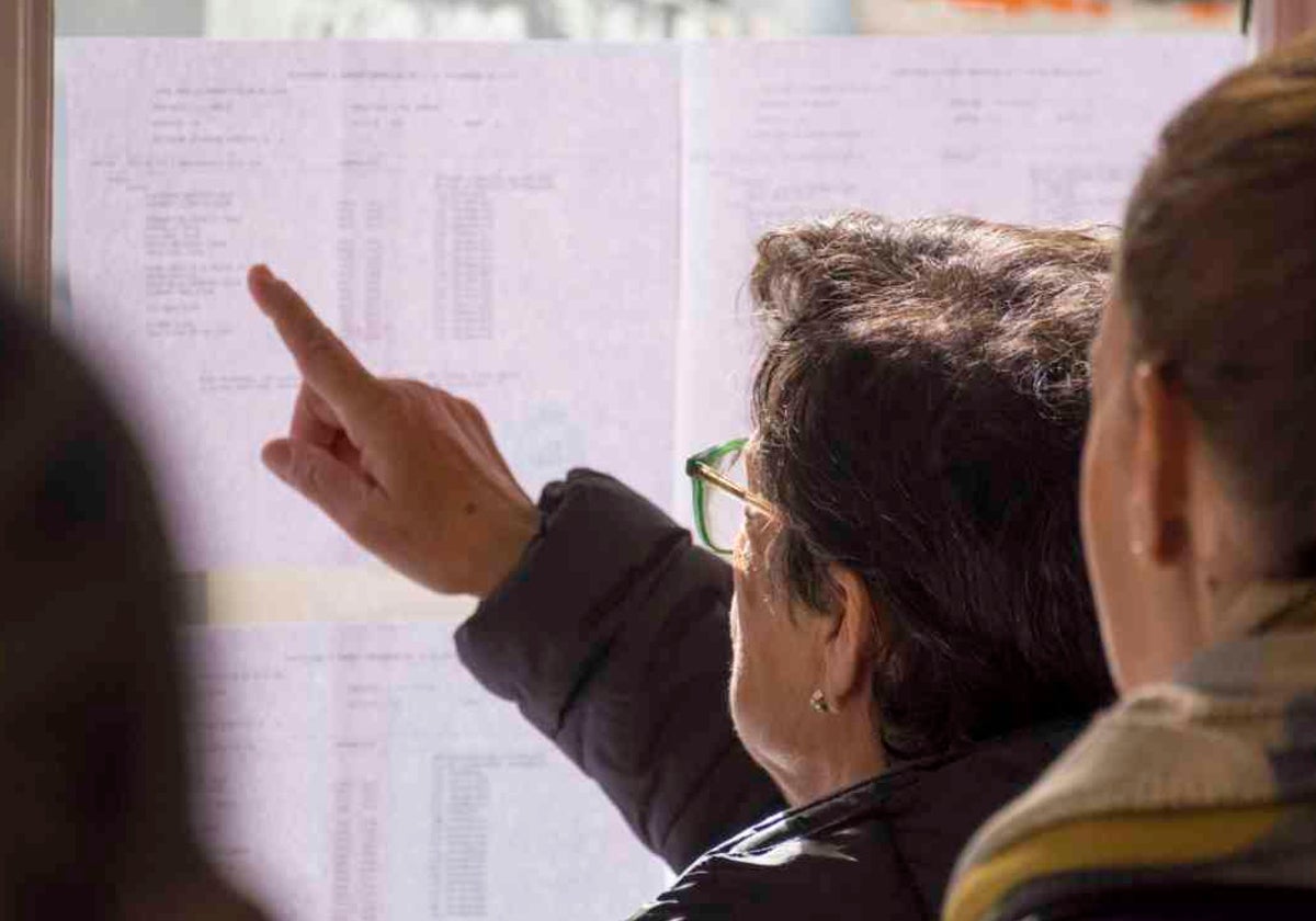 Una elector busca su nombre antes de votar