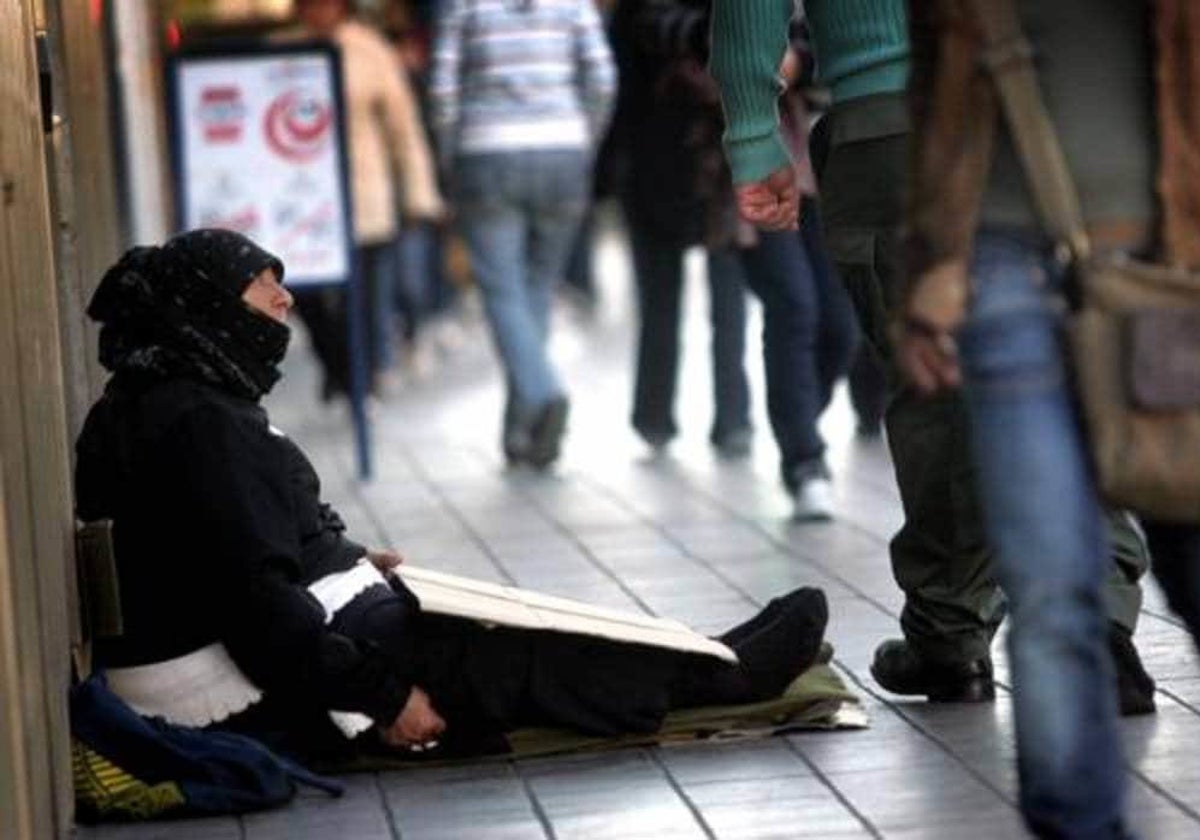 Una mujer pidiendo limosna en la calle