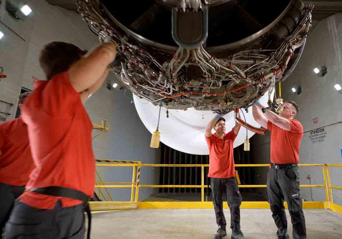 Técnicos manipulan un motor de turbina