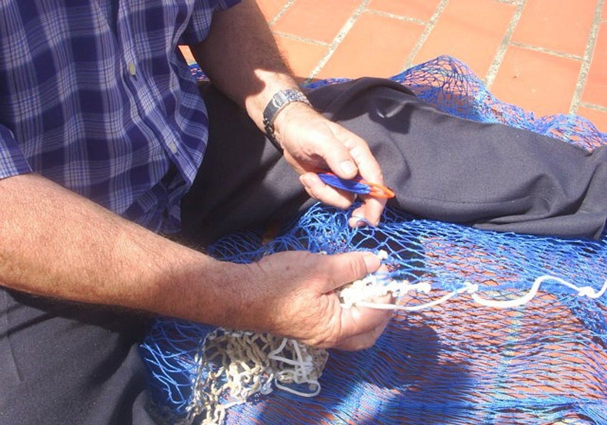 Un pescador arregla unas redes