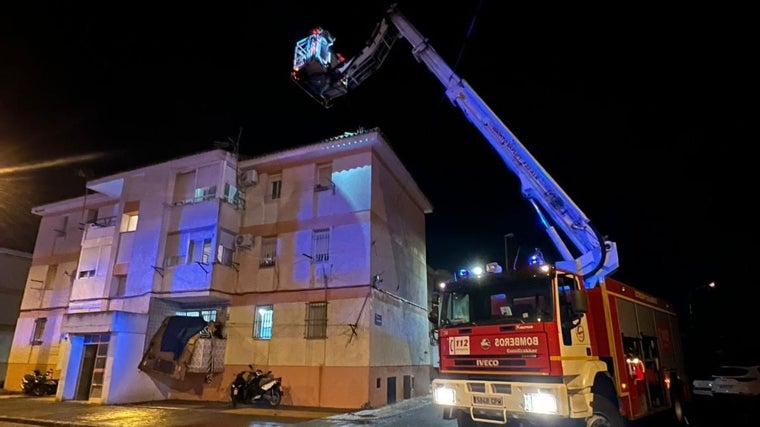 Bomberos retiran tejas de un tejado dañado en una vivienda a causa del tornado