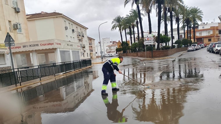 Un trabajador del Ayuntamiento quitando grandes charcos de agua en una carretera de la localidad olontense