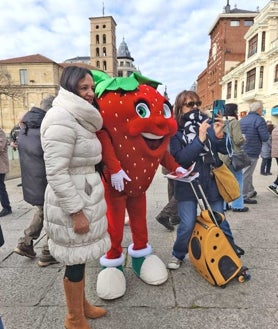 Imagen secundaria 2 - Arriba, la larga cola que se formó para recoger una de las tarrinas que se regalaron el jueves en el centro de León y sobre estas líneas, el 'stand' de la UPA y la mascota de la campaña fotografiándose con vecinos de la capital leonesa