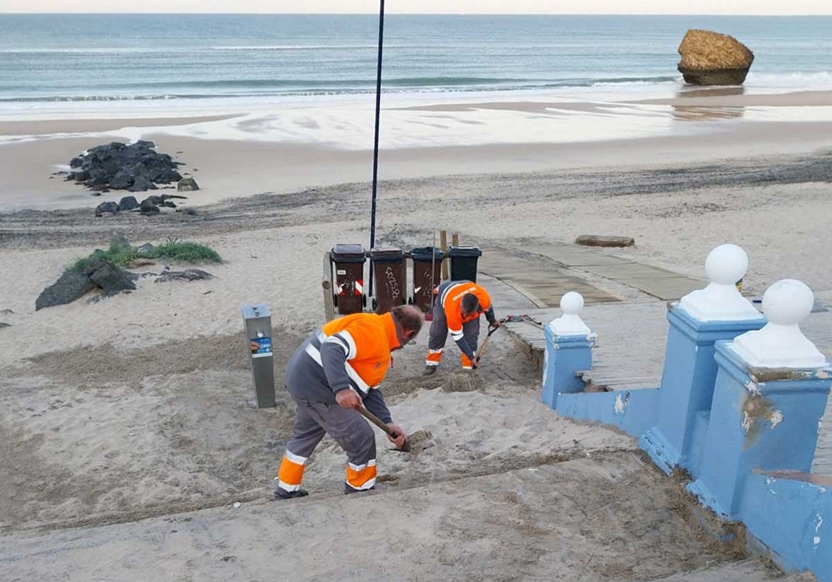 Operarios trabajan retirando arena de uno de los accesos