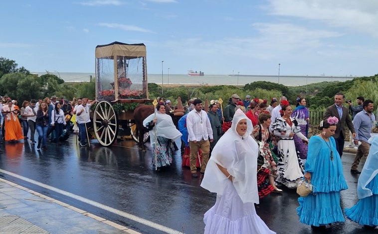 Imagen principal - Mazagón esboza una sonrisa pese al mal tiempo en el inicio de su romería en honor a la Virgen del Carmen