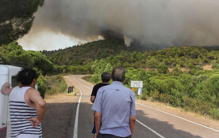 Vecinos de Nerva observan las tareas de extinción de un incendio en 2018